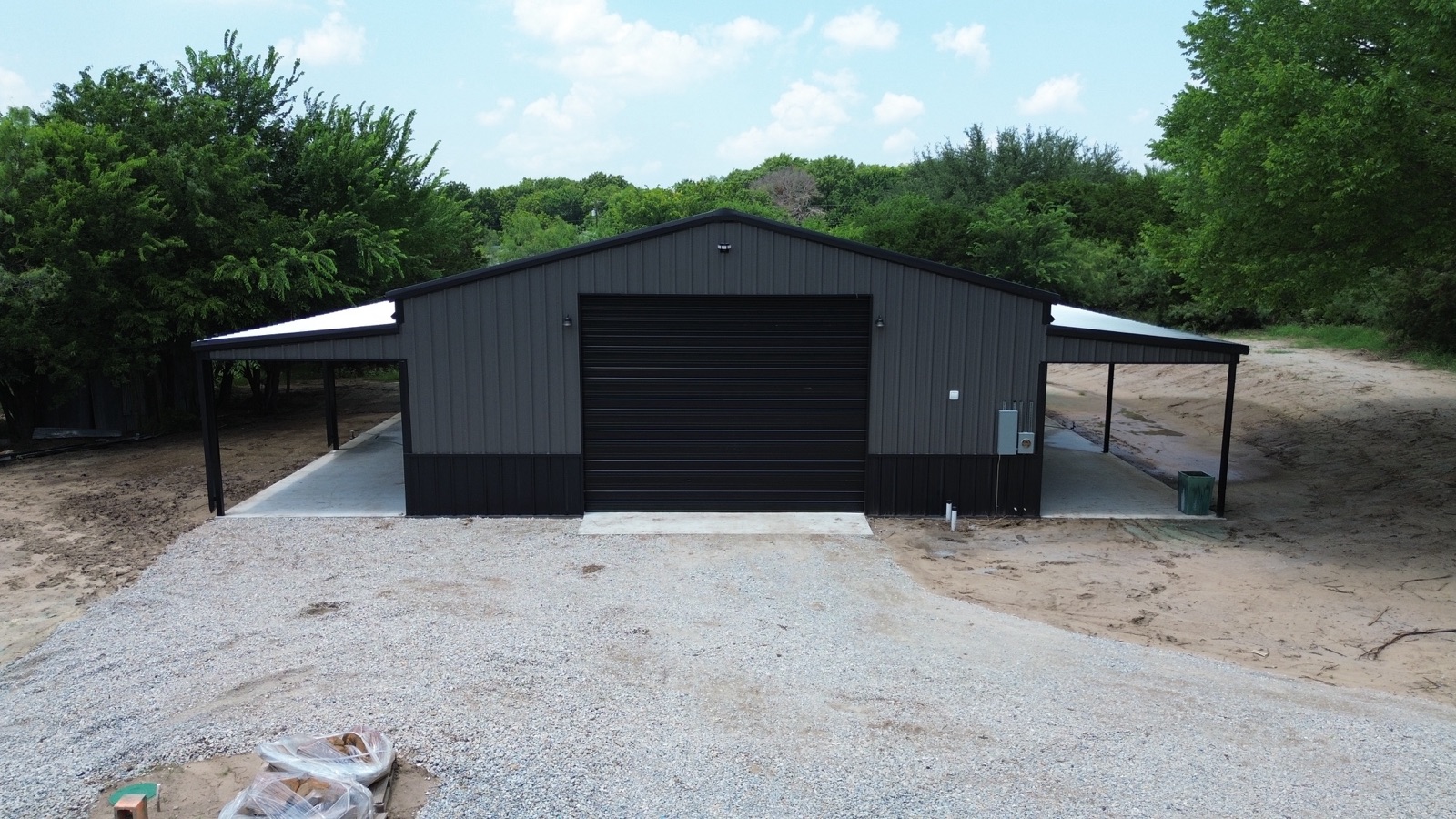 Steel shop with covered lean-tos in North Texas, aerial view